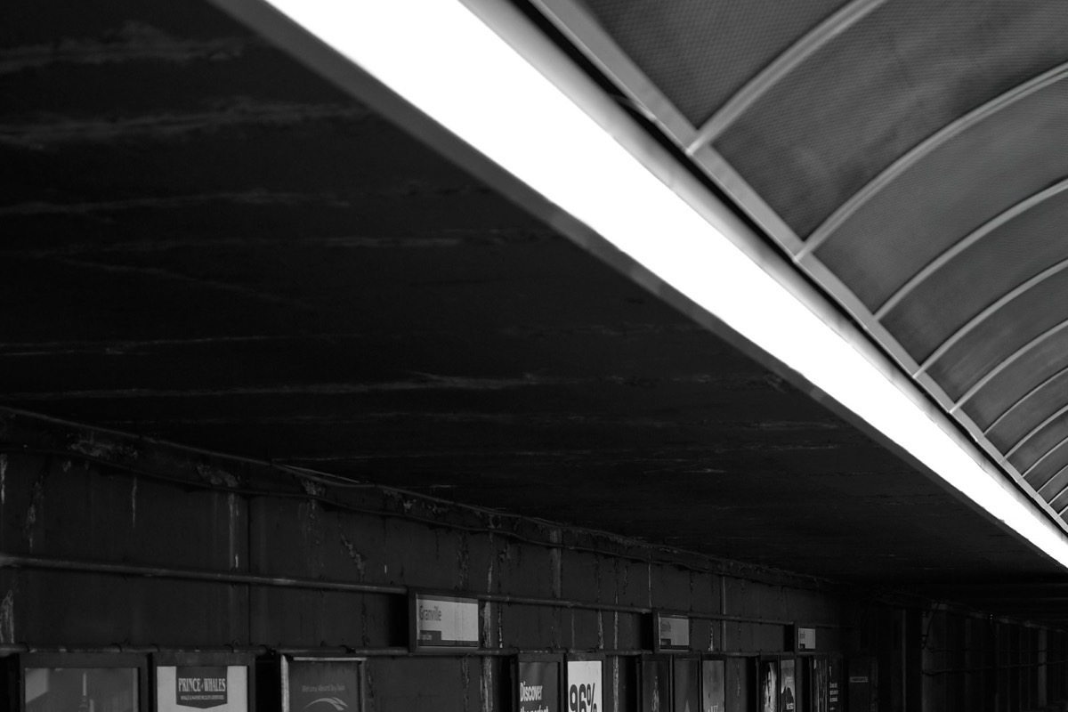 Un quai de métro presque vide, sous un long néon.